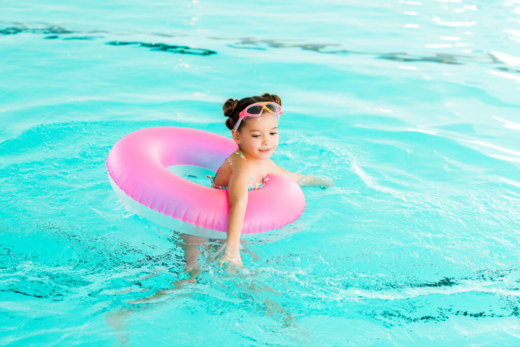 Kind hat einen Schwimmreifen beim Schwimmen an. Diese empfehlen wir nicht. Zur Wassergewöhnung kann man sie benutzen, zum Schwimmenlernen sind sie nicht geeignet.